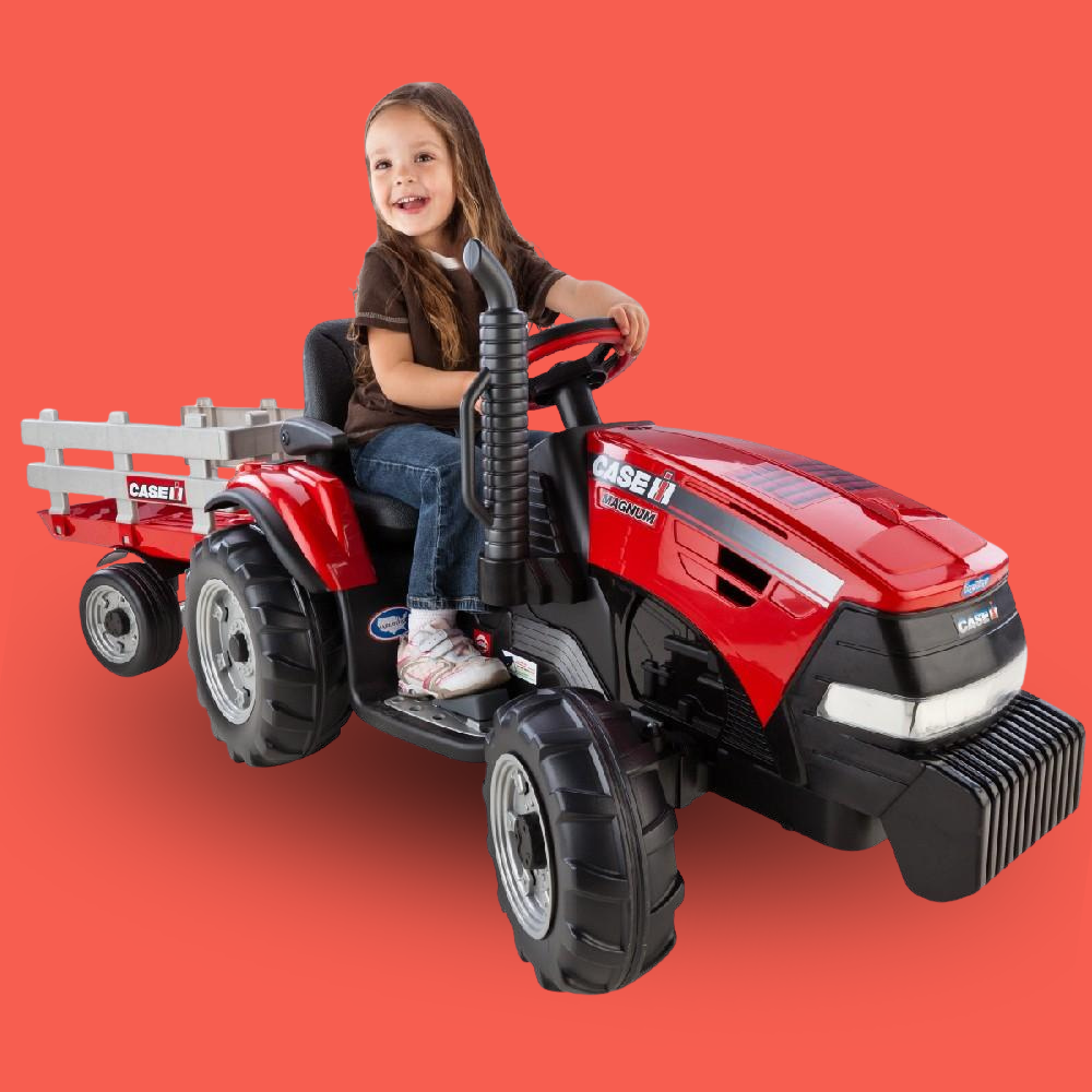 Child sitting on a red toy tractor against a red background