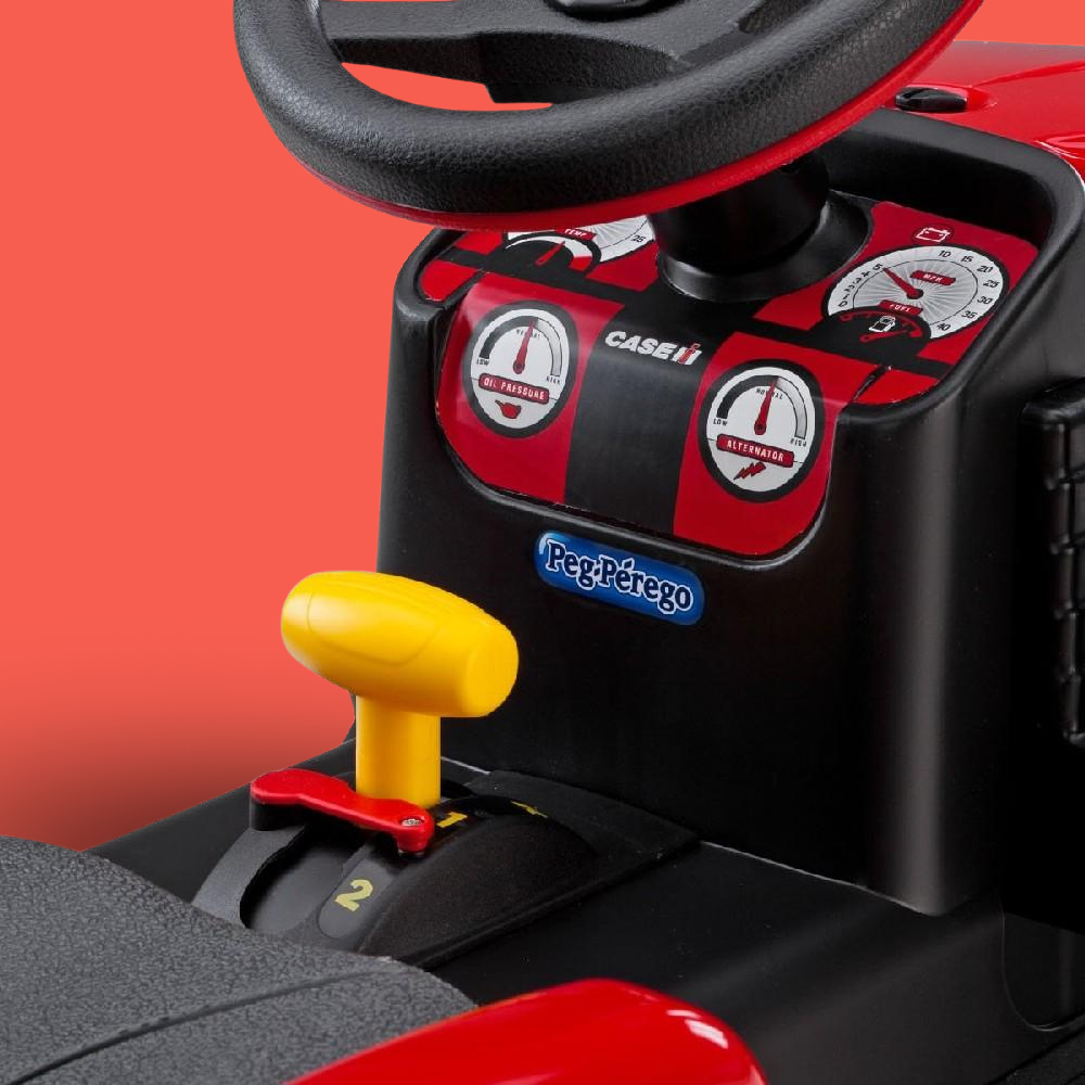 Toy tractor steering wheel and dashboard with Peg Perego branding on a red background