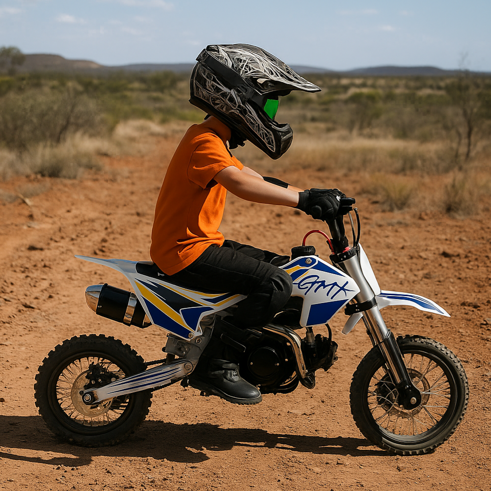 Child rider wearing safety gear riding the GMX 125cc dirt bike across a dry, rural dirt track.