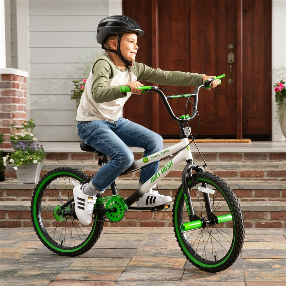 Child riding a bicycle with training wheels on a porch