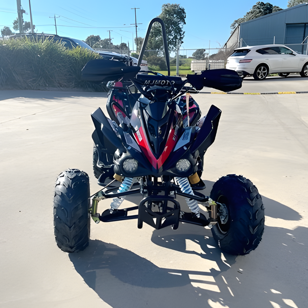 ATV on a paved surface with vehicles and buildings in the background