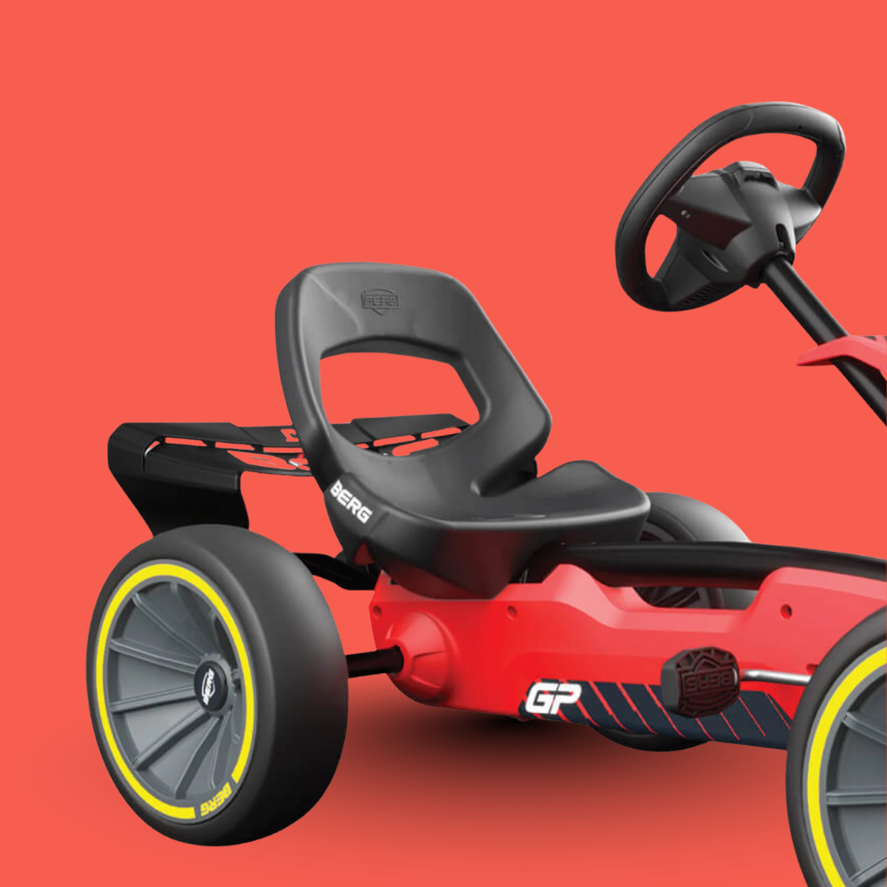 Red and black pedal go-kart with yellow rim on a red background