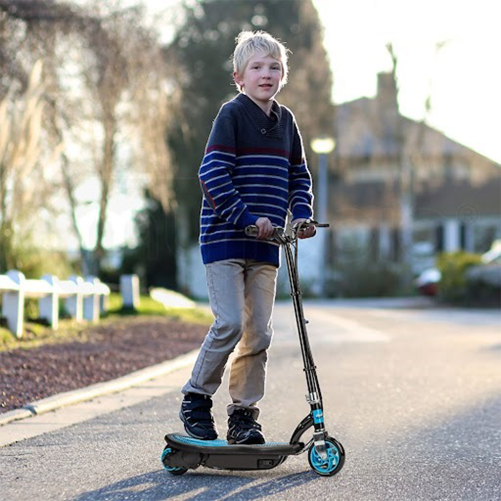 A lifestyle image of a young boy riding the scooter outdoors on a sunny day, showcasing the scooter's usability and fun factor.