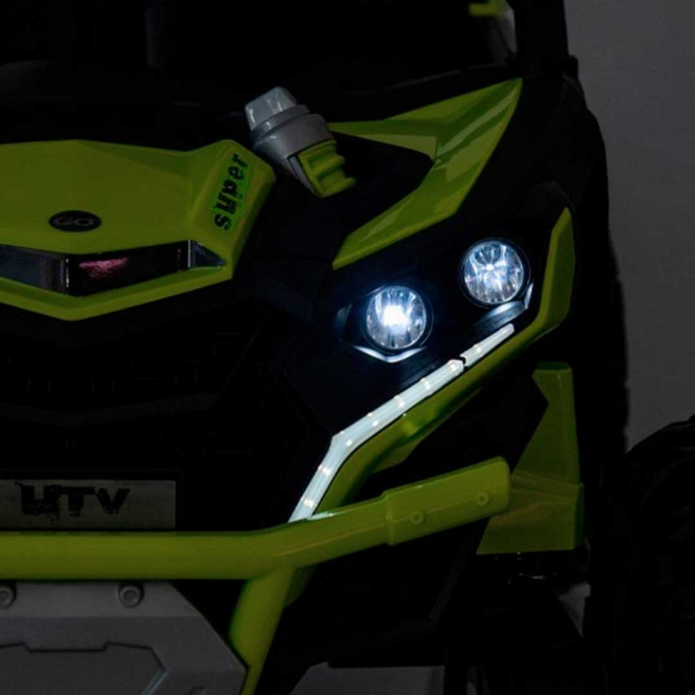 Close-up of a green and black off-road vehicle with illuminated headlights.