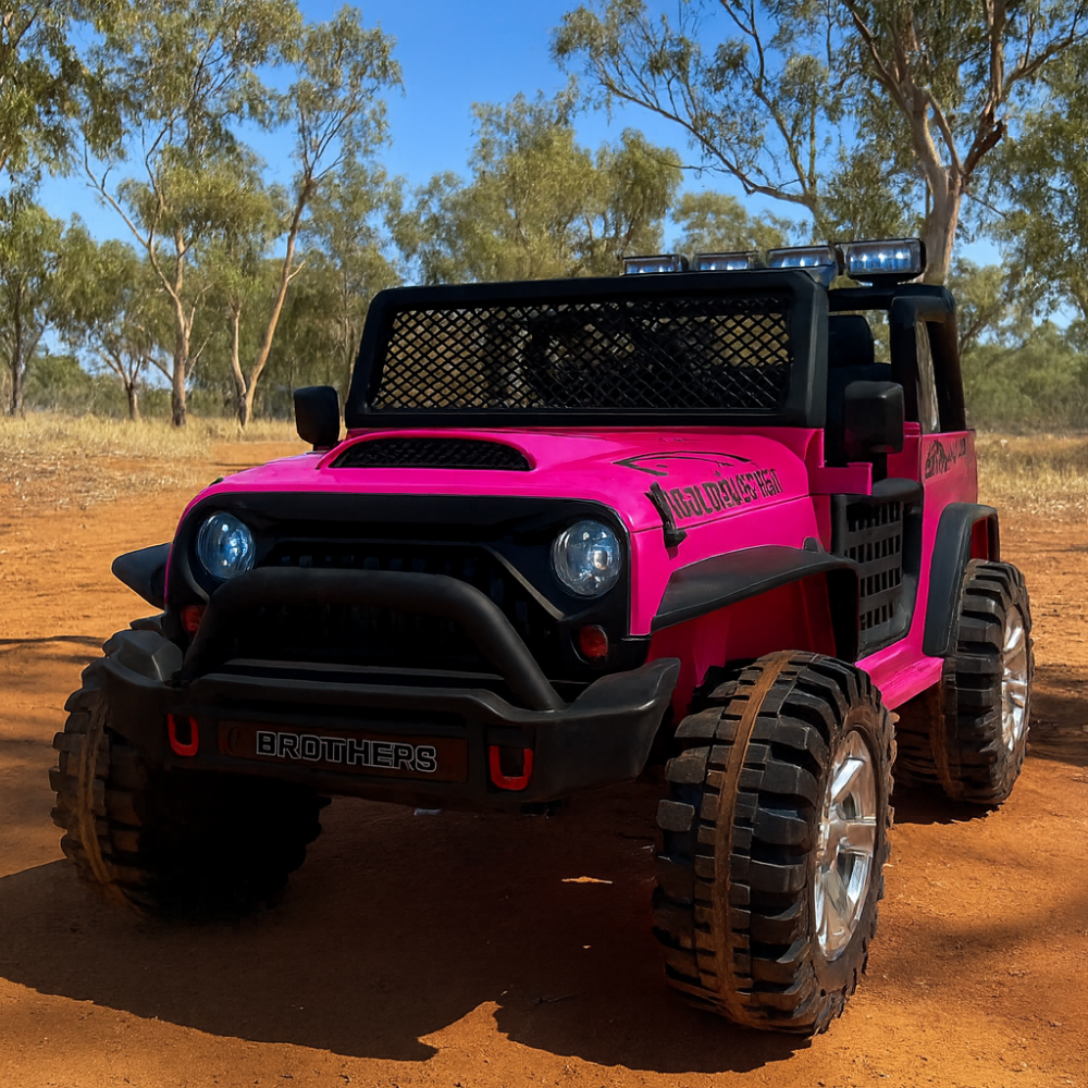 Pink toy truck with large wheels on a dirt road surrounded by trees