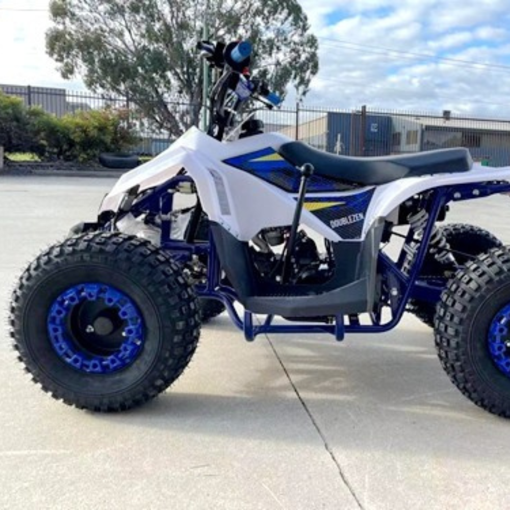 White and blue ATV on a concrete surface with trees and buildings in the background