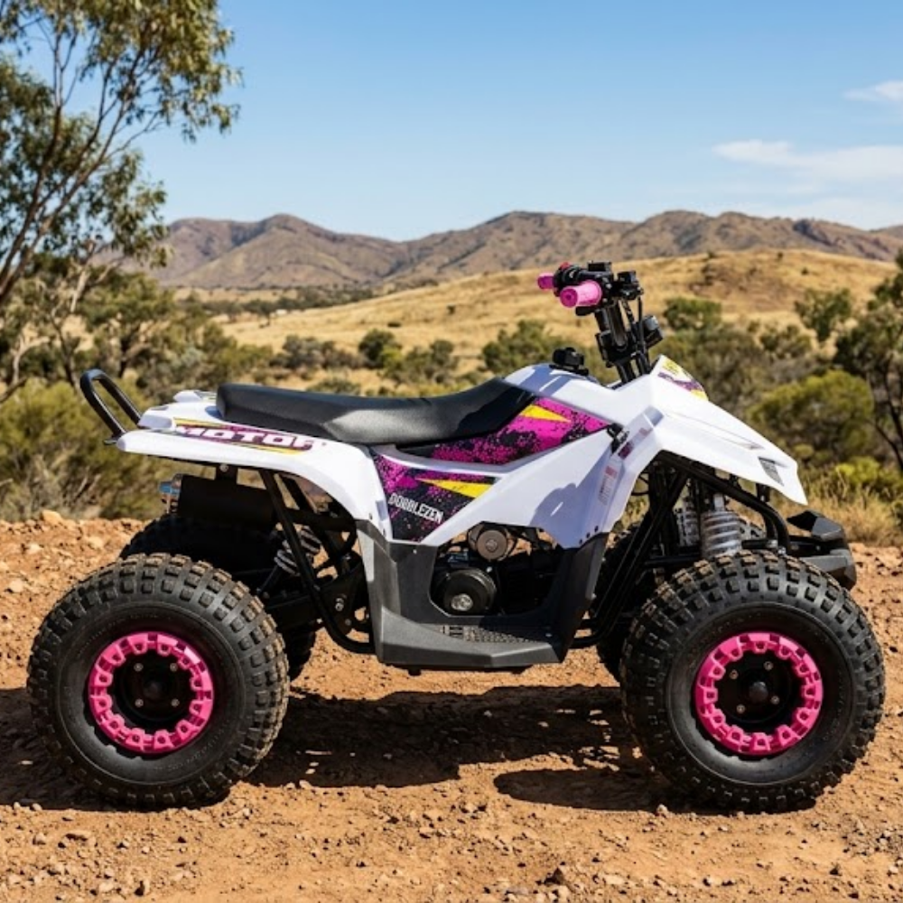A white and black quad bike ATV with bright pink wheel rims, parked outdoors on a dirt trail with hills and trees in the background.