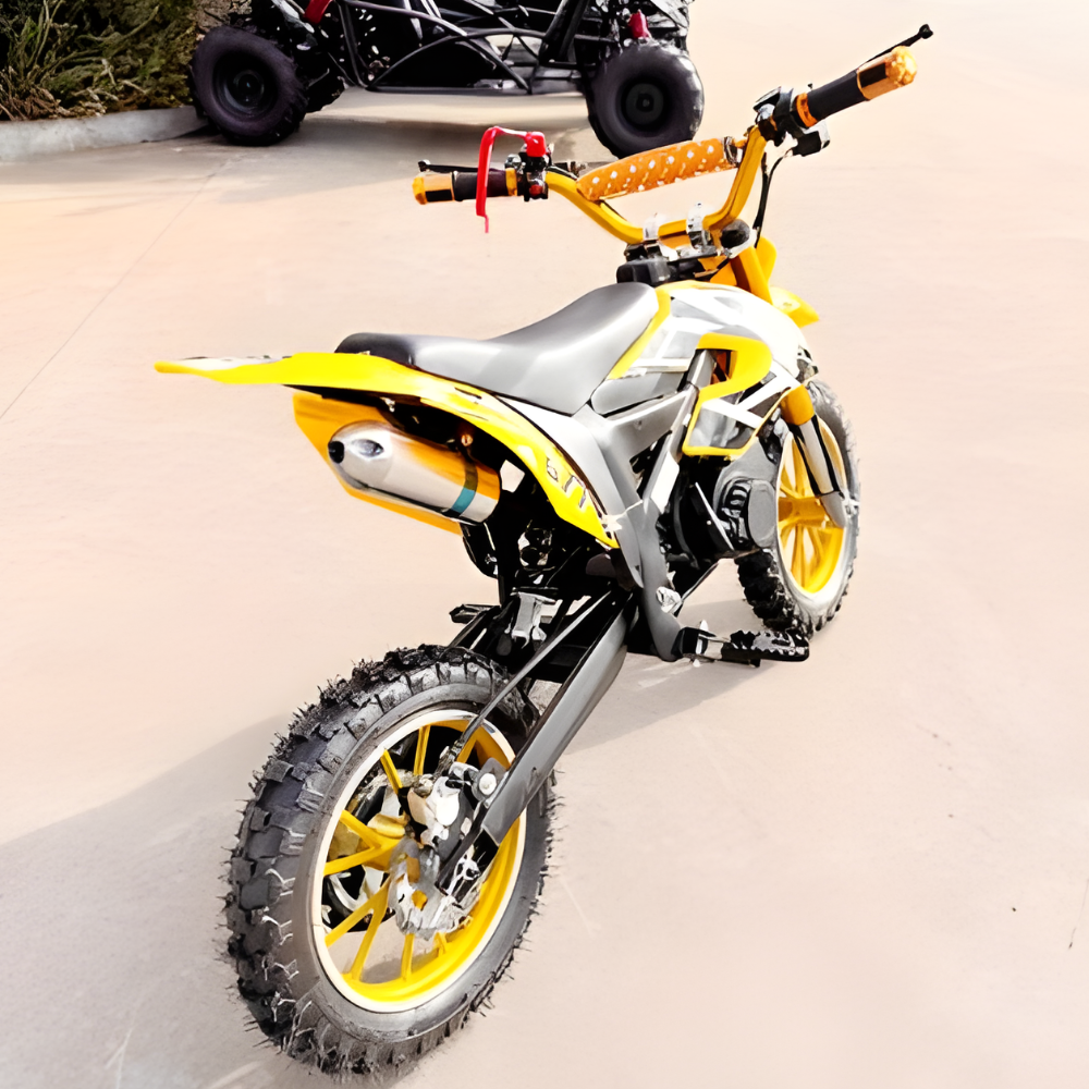Yellow and gray dirt bike on a concrete surface with a blurred background