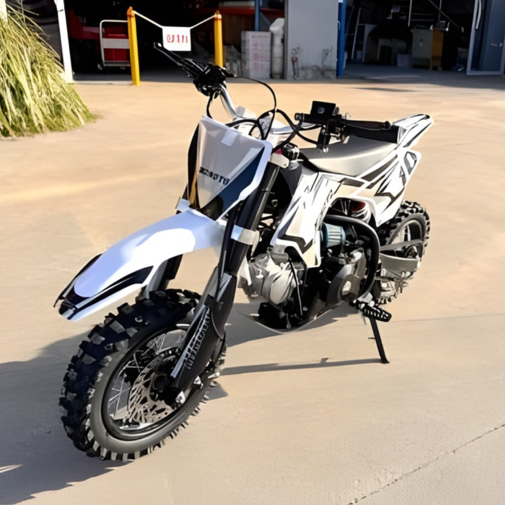 White and black dirt bike on a concrete surface with a blurred background