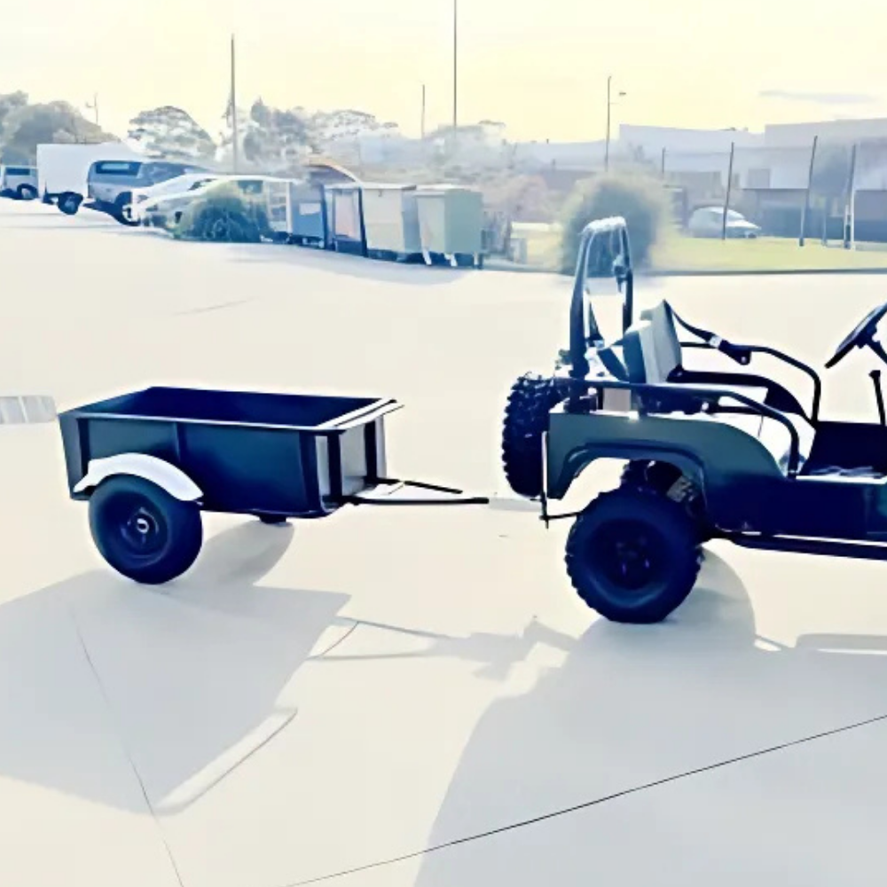 Black cart with a small trailer attached on a paved surface.