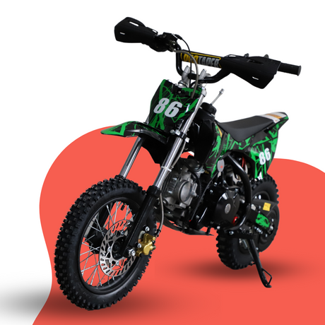 Front-angled studio shot of a red and black 50cc kids’ dirt bike with number 86 graphics, displayed on a red and grey backdrop.