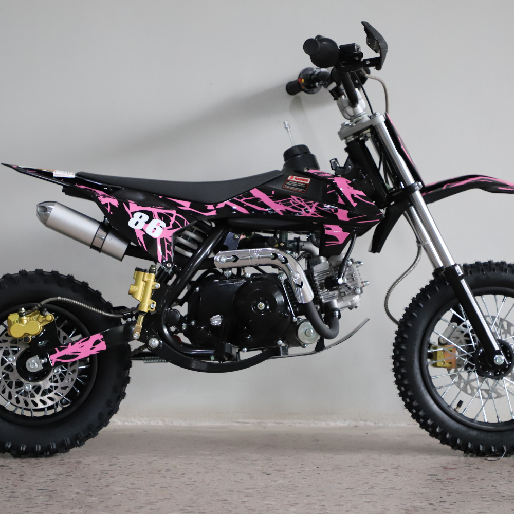 Left-side studio image of the dirt bike, highlighting fuel tank, seat contour, and pink graphic styling.