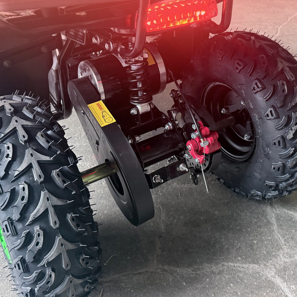 Close-up of a vehicle's suspension system with large tires on a concrete surface.