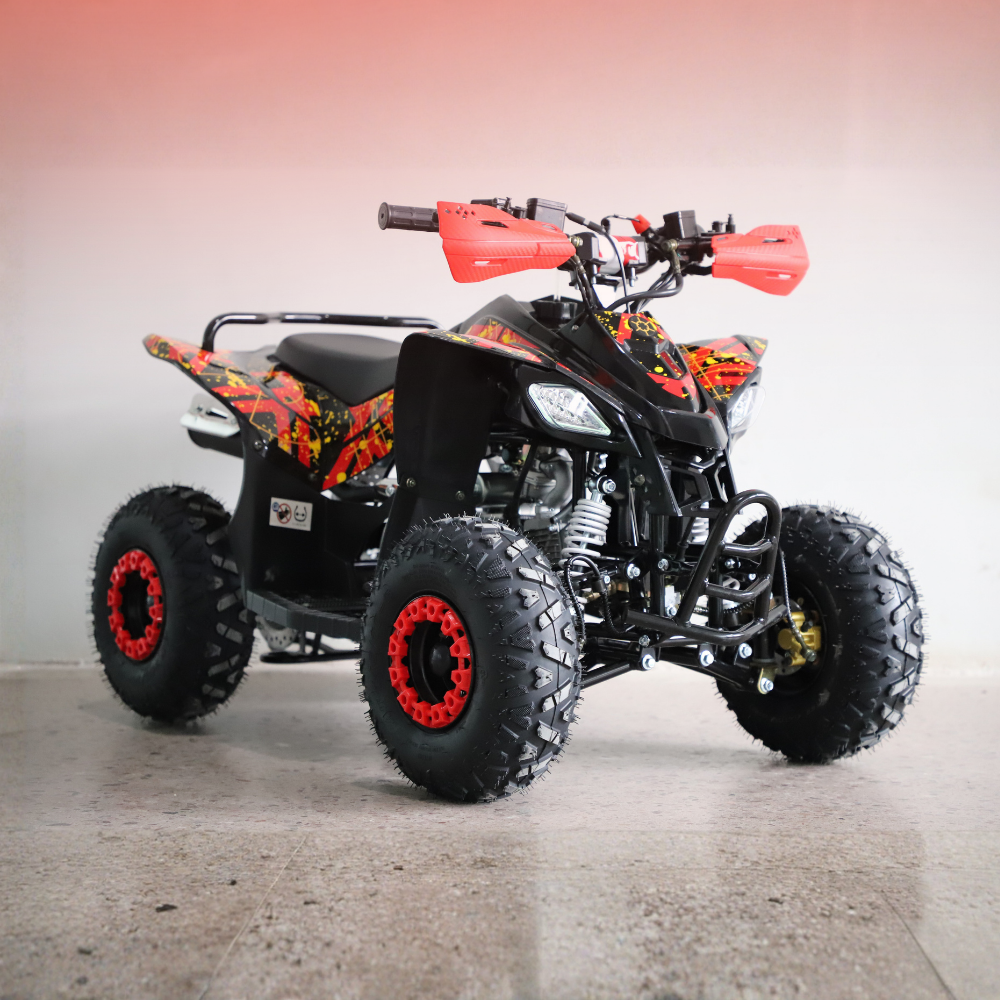 A black mini ATV quad bike with vibrant red and orange flame graphics on the body panels, black seat, and red-rimmed wheels, photographed in a studio setting.