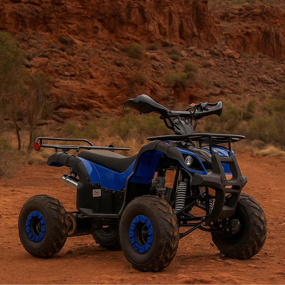 Outdoor shot of blue kids quad bike, parked in red dirt terrain with natural cliffs in the background.