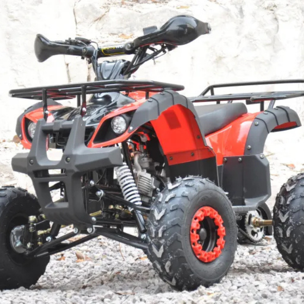 Rear angle of red quad bike, positioned outdoors on rocks with tyres and exhaust visible.