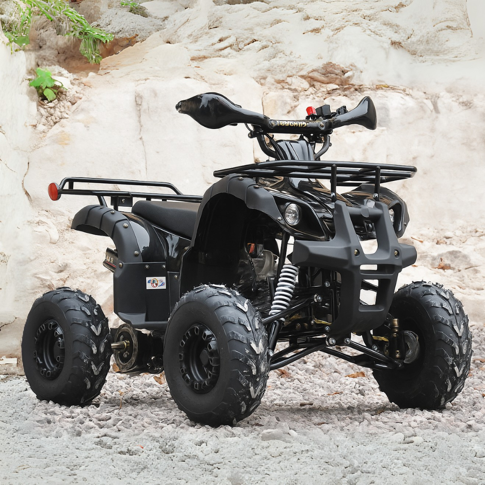 Outdoor shot of black kids quad bike, parked in red dirt terrain with natural cliffs in the background.