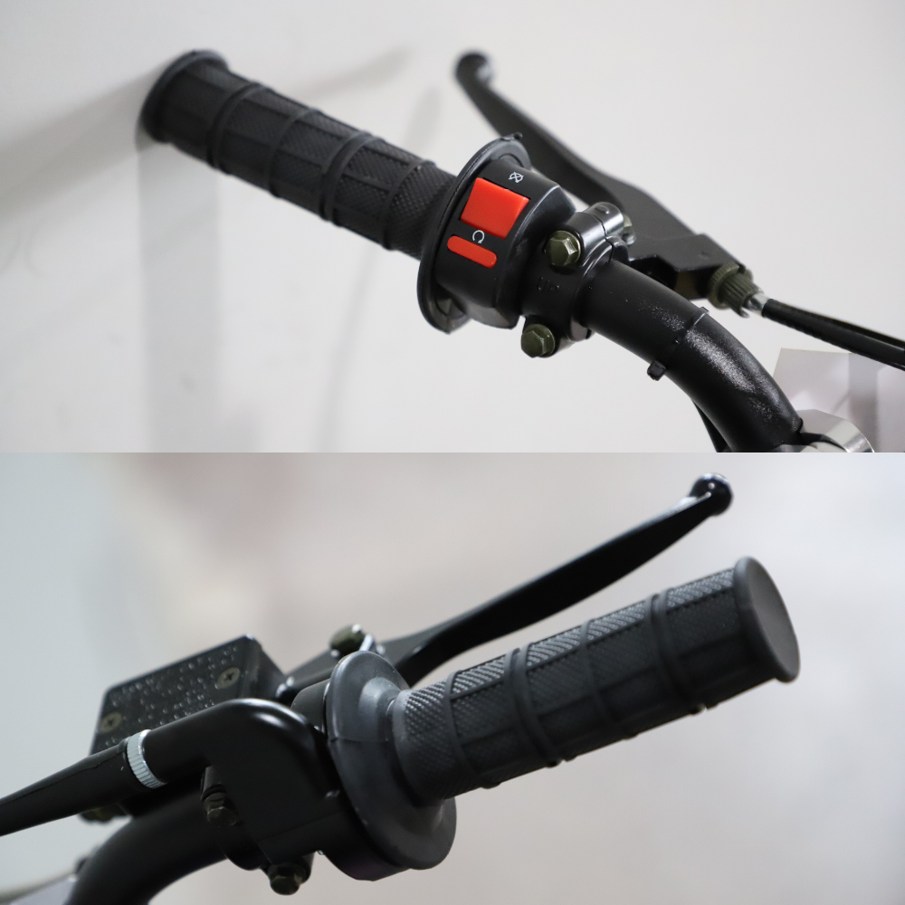 Close-up of motorcycle handlebar with black grips and red switch on a white background