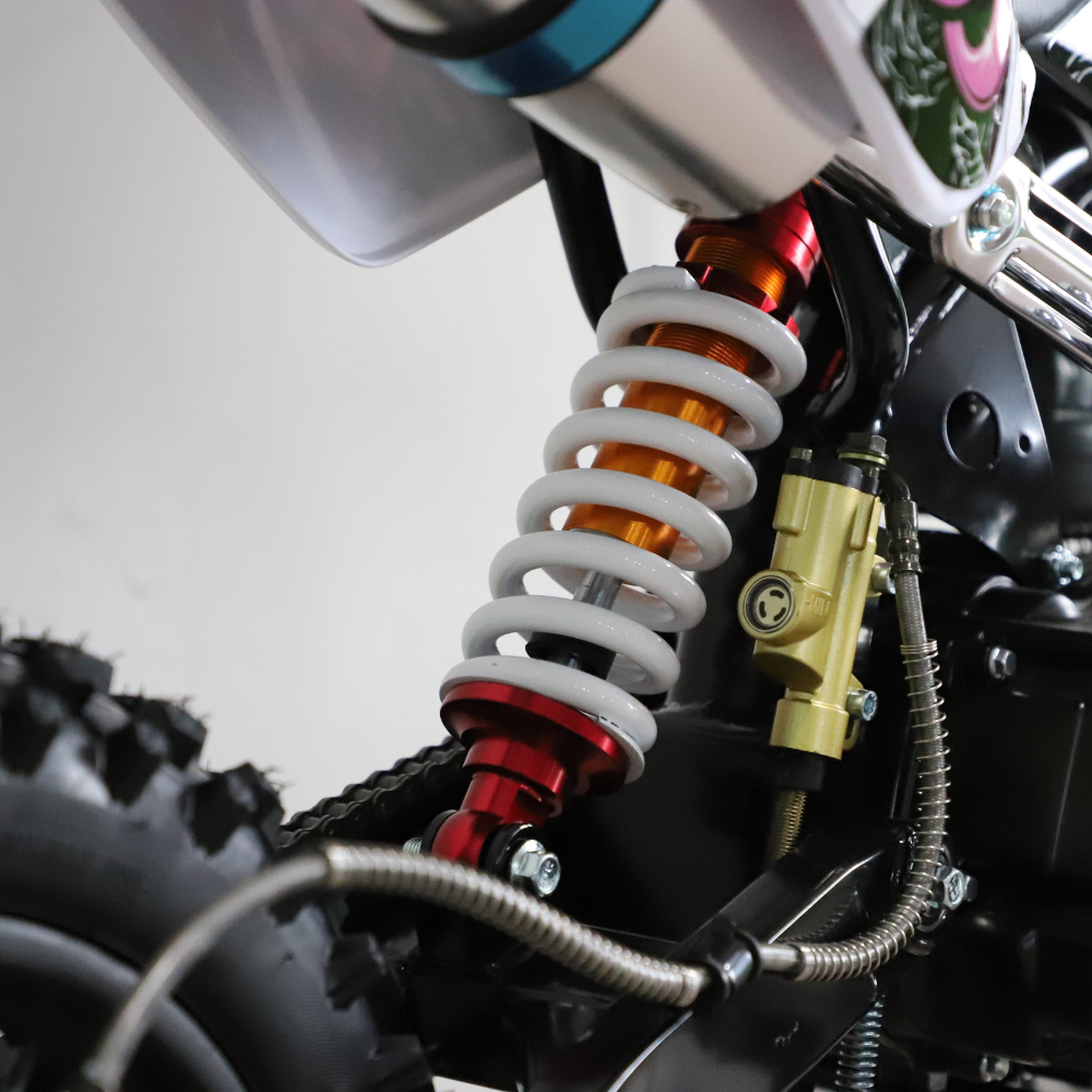 Close-up of a motorcycle suspension system with visible branding on a white background