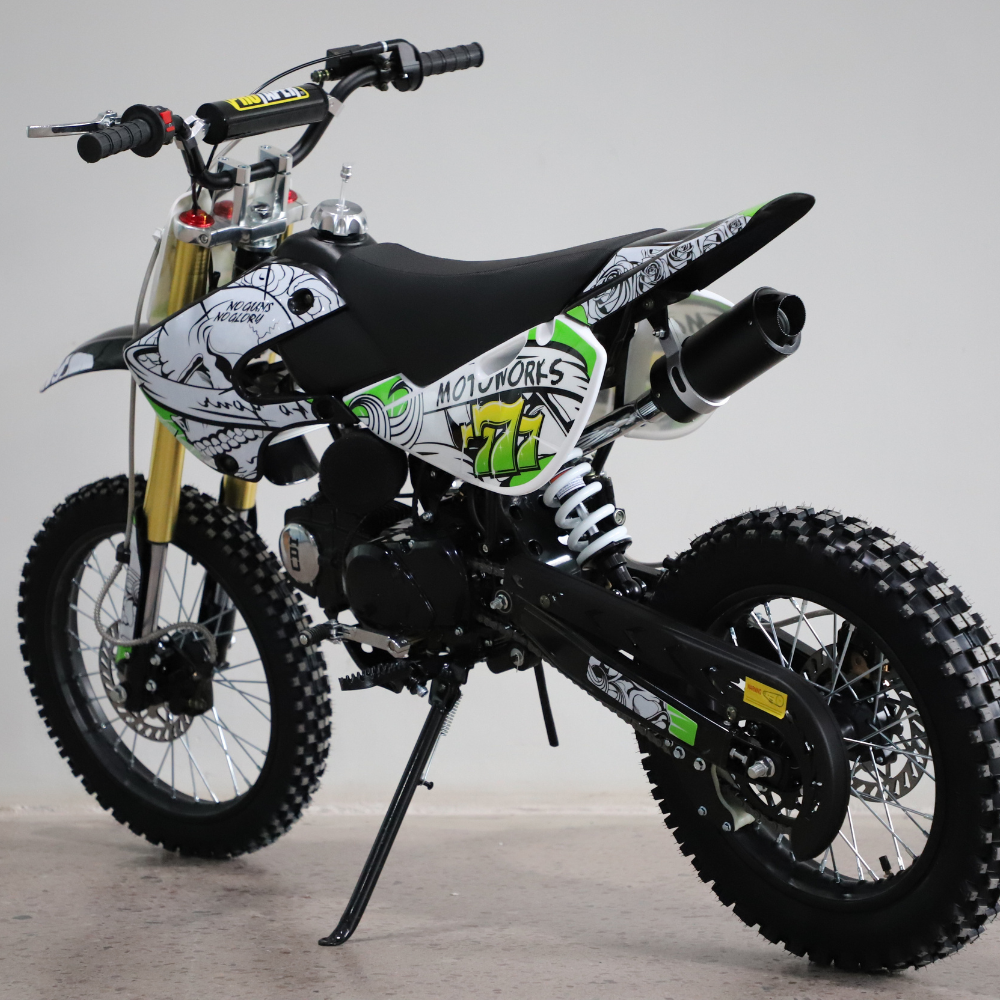 Left-side view of the dirt bike in a studio, showcasing tyres, chain, and engine housing.
