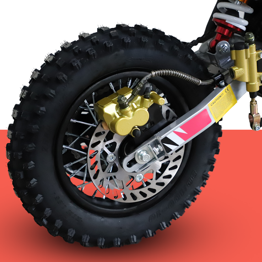 A close-up of the dirt bike’s front wheel and suspension, highlighting the braking system and tyre tread.