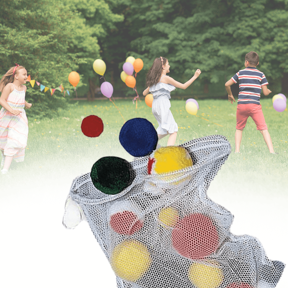 Three children running in a field with colourful balloons in the background, with a mesh bag filled with fleece balls in the foreground