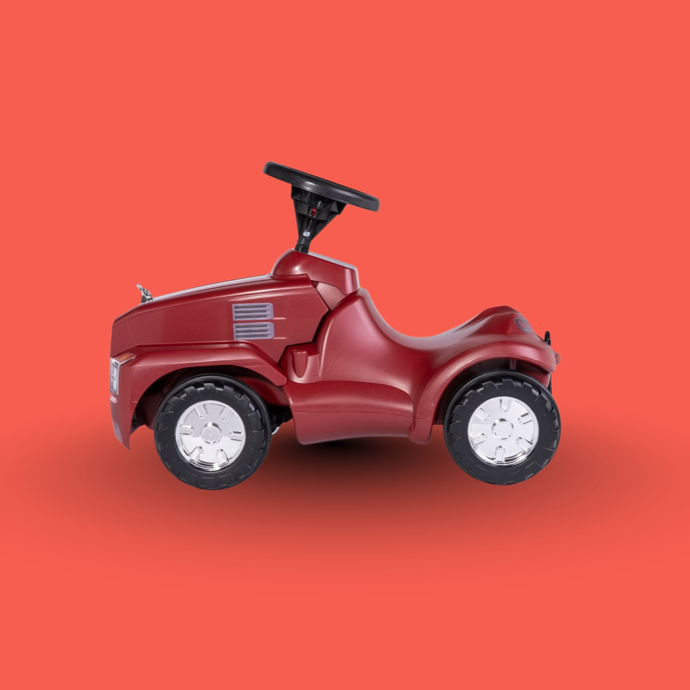 Red toy car with a black steering wheel on an orange background
