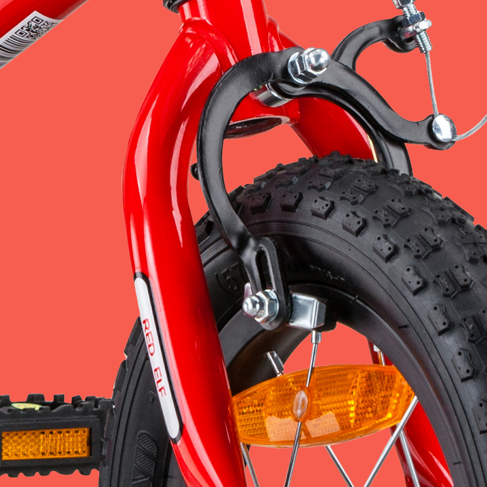 Close-up of a red bicycle with a black tire and orange reflector on a red background