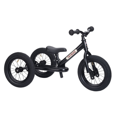 Black balance bike with training wheels on a white background