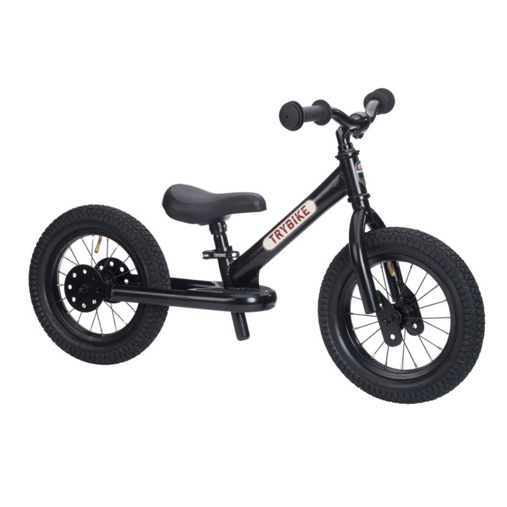 Black balance bike with a seat on a white background