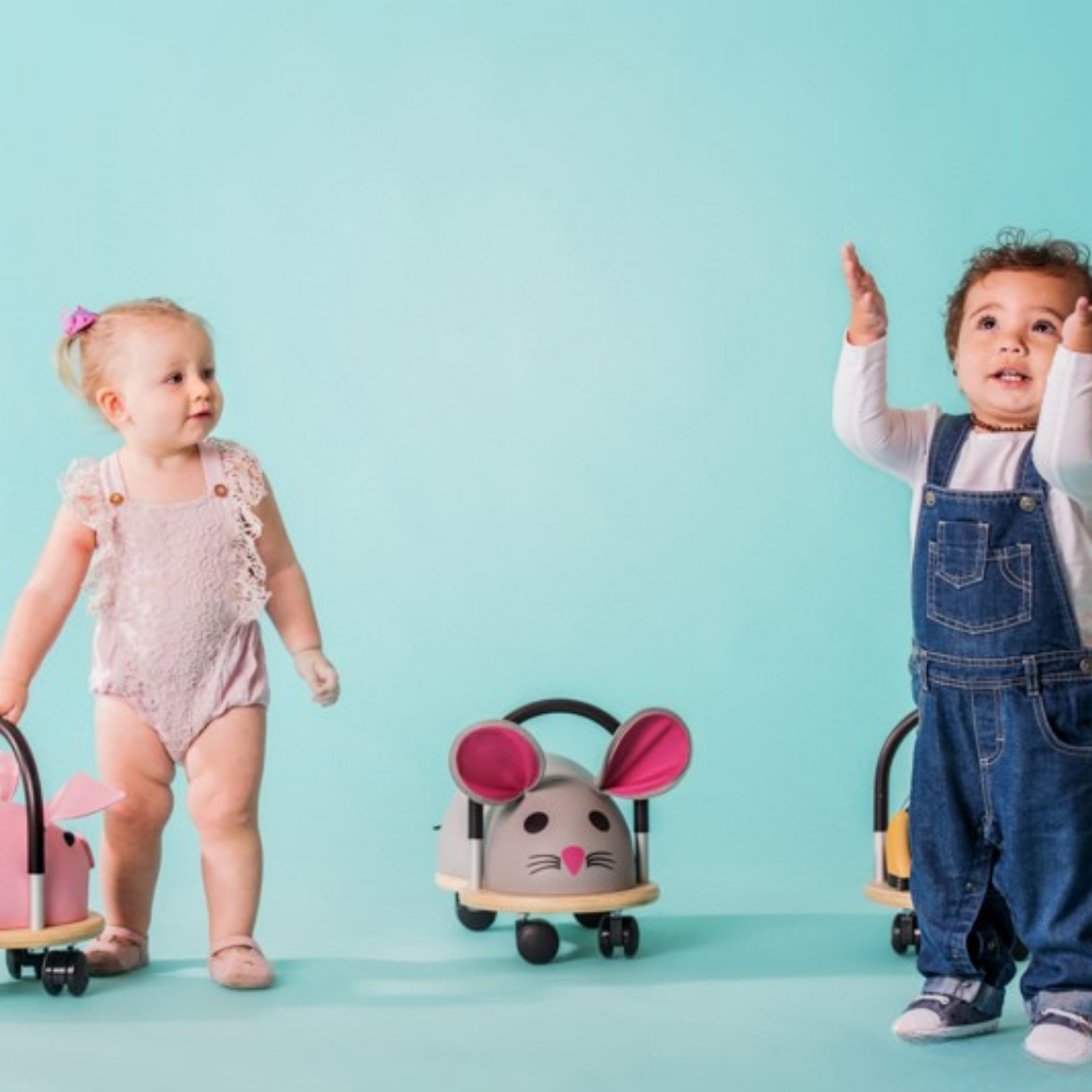 Two children with toy mouse cars on a light blue background