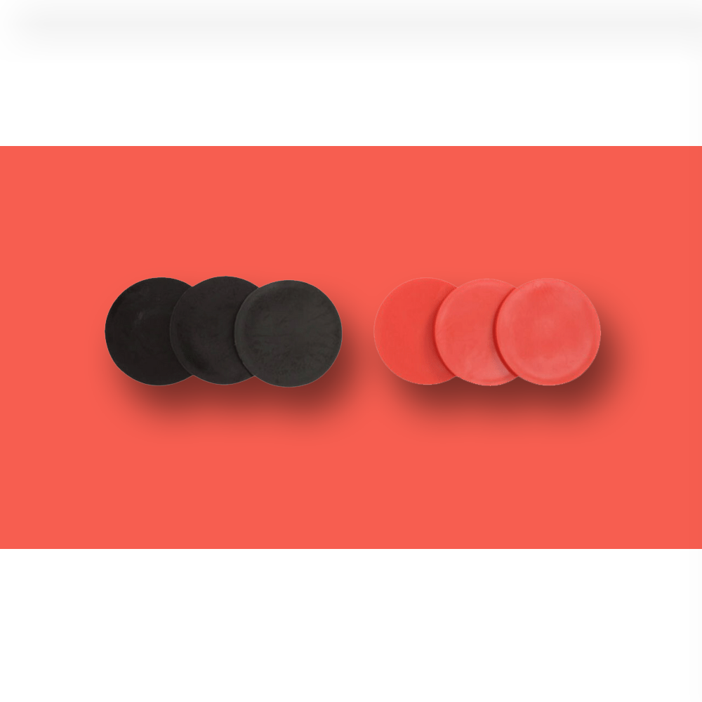 "Close-up image of black and red circular game tokens used for a giant Connect Four game, placed against a red background."