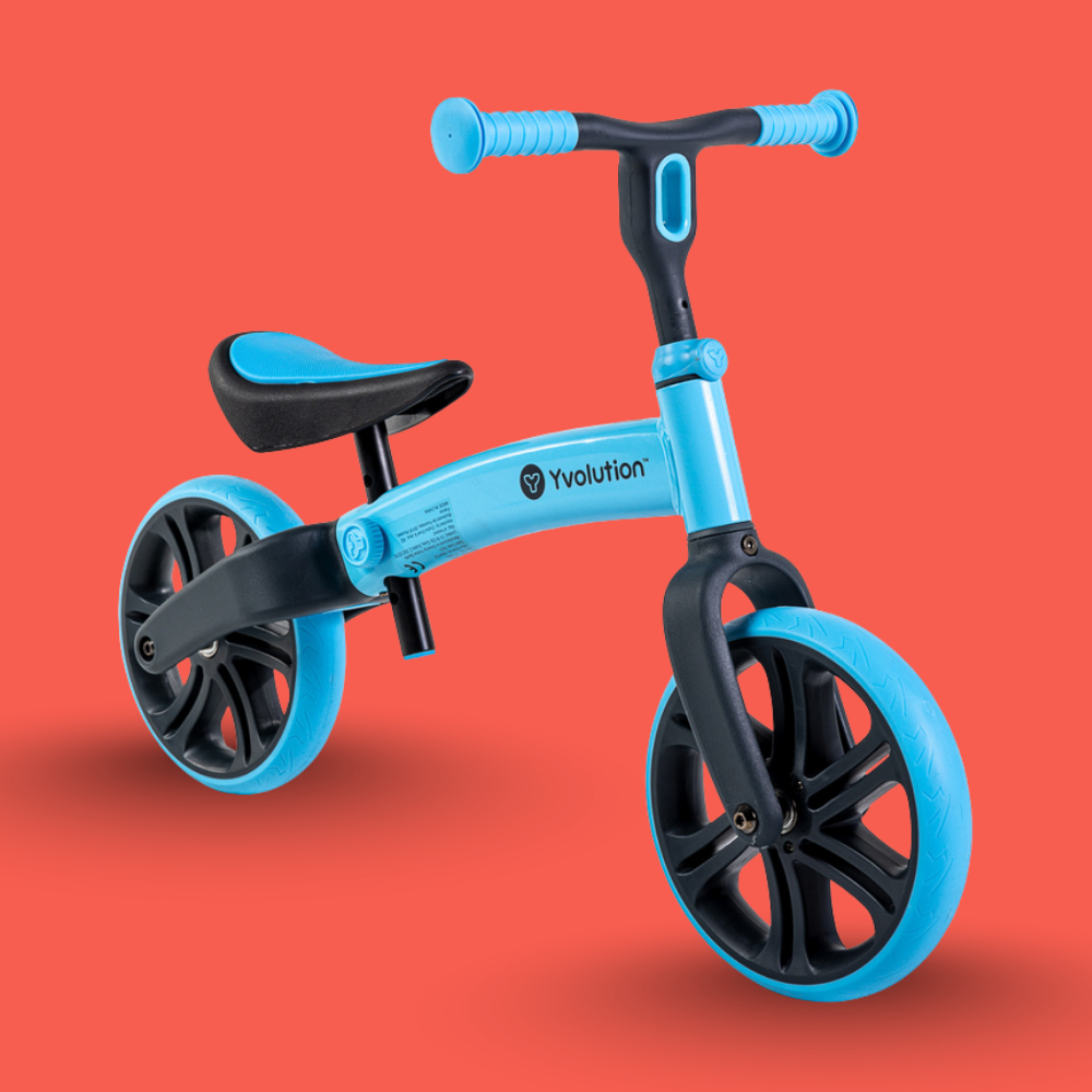 Blue balance bike with black wheels on an orange background