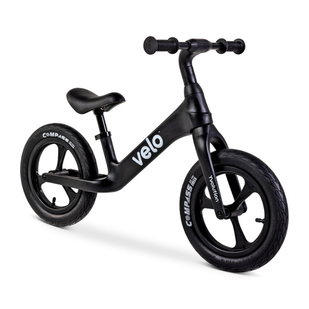 Black balance bike with 'velo' branding on a white background