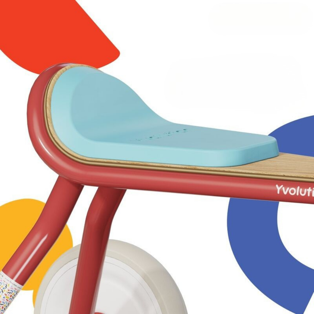 Children's balance bike with colorful geometric shapes in the background