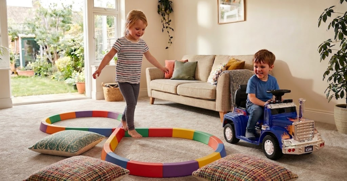 two happy kids play with blocks, a rainbow tunnel, and a blue ride-on truck.