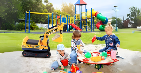 Three children playing in a sandbox with colourful toys, next to a small yellow toy excavator. A vibrant playground with slides and climbing structures can be seen in the background