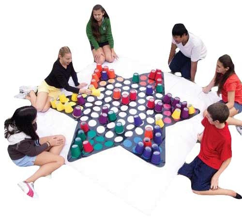 six people playing a giant game of chinese checkers sitting down
