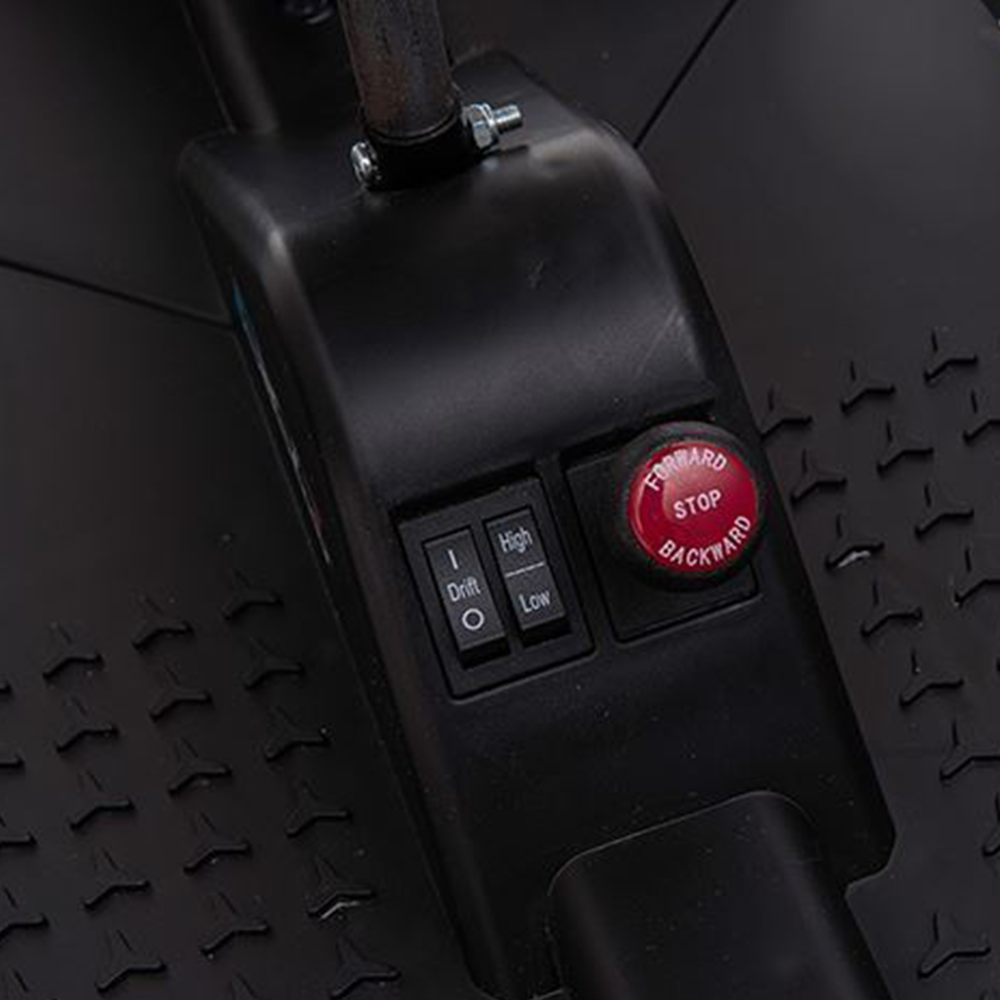 A close-up of the go-kart’s foot pedal and control area, featuring a visible red power button and textured footrest.