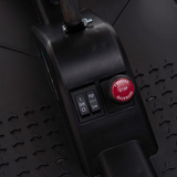 A close-up of the go-kart’s foot pedal and control area, featuring a visible red power button and textured footrest.