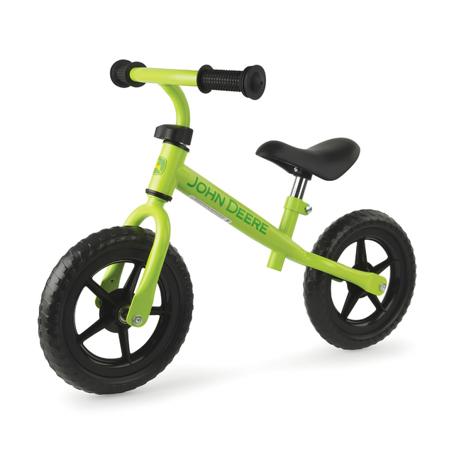 Green balance bike with black handlebars and wheels on a white background