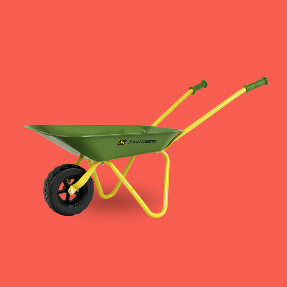 A John Deere wheelbarrow with a green metal tray, yellow frame and handles, and a black tire, shown against a solid coral red background.
