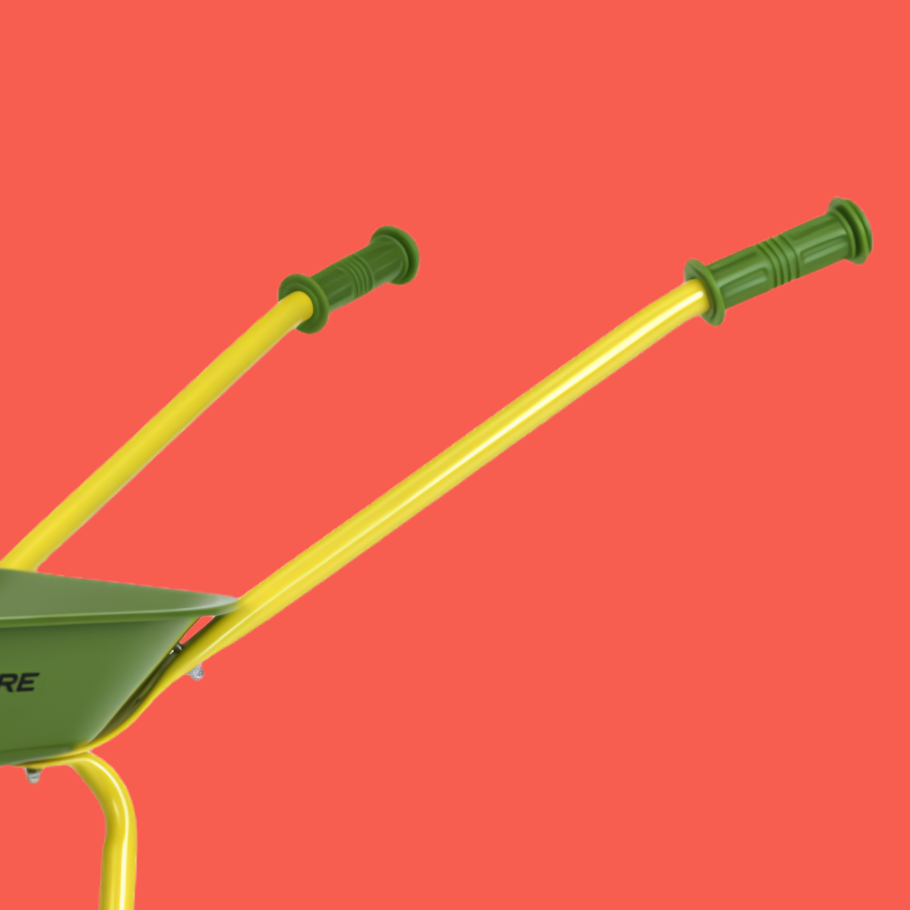 Close-up of a wheelbarrow with a green metal bowl and green handles, set against a solid coral red background.