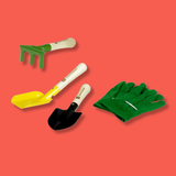 A gardening set with a green hand fork, a yellow and white plastic shovel, a black and white hand trowel, and a pair of green gloves, arranged on a solid coral-red background.