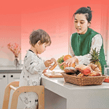 A wooden learning tower helps toddlers safely reach counter height to participate in kitchen tasks and handwashing.