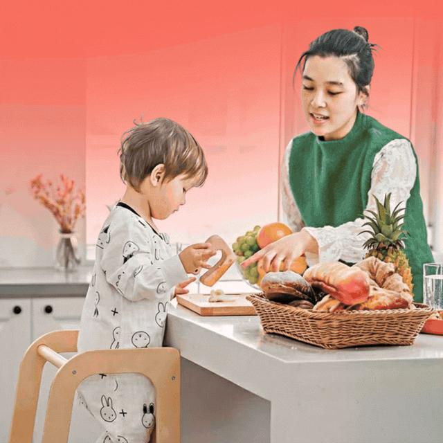 A wooden learning tower helps toddlers safely reach counter height to participate in kitchen tasks and handwashing.