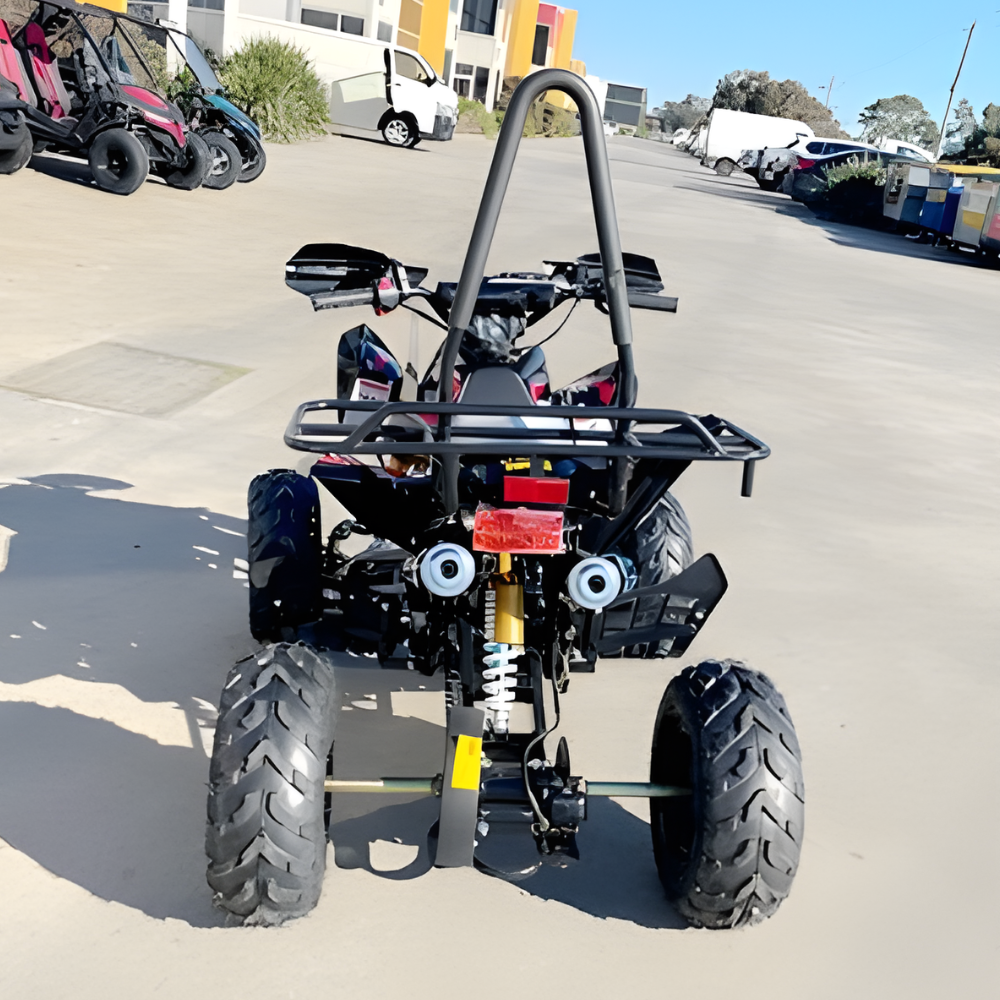 Small off-road vehicle on a paved surface with buildings and vehicles in the background