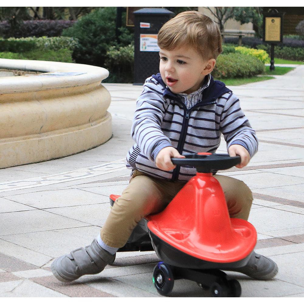 A lifestyle shot of a child riding the red version of the toy outdoors, demonstrating the product's size and functionality in real-life use.