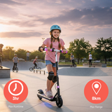 Child riding a scooter at a skate park with sunset sky
