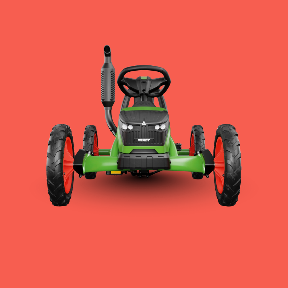 Green toy lawn mower with black wheels on a red background